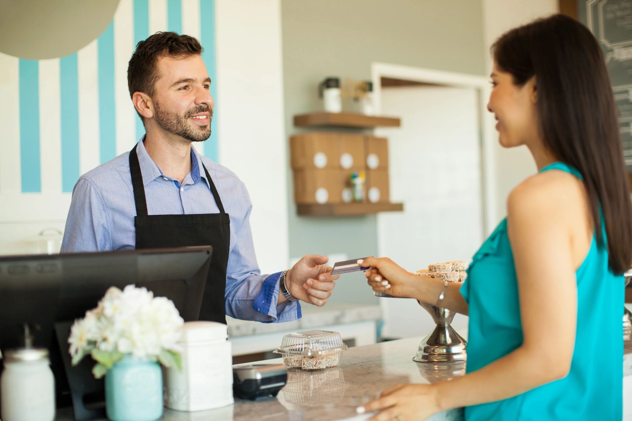 A coffee barista and a customer exchanging money.